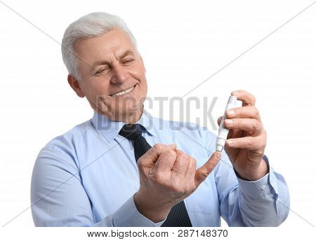 Senior Man Using Lancet Pen On White Background. Diabetes Control