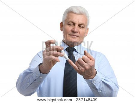 Senior Man Using Lancet Pen On White Background. Diabetes Control