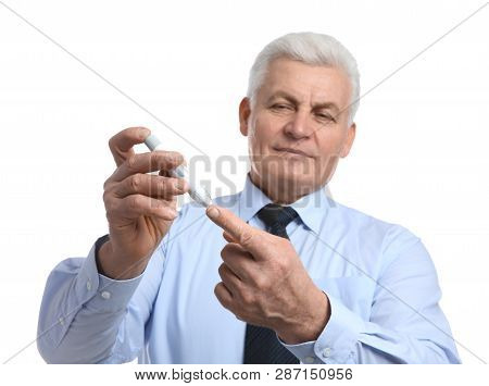 Senior Man Using Lancet Pen On White Background. Diabetes Control