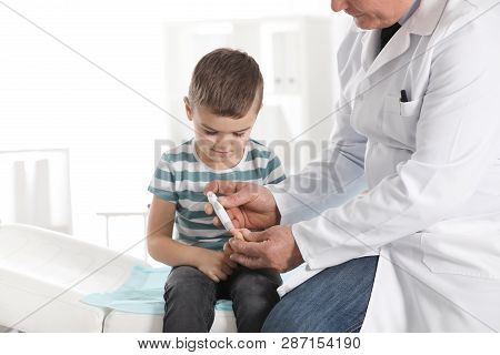 Little Patient And Doctor With Lancet Pen In Hospital. Diabetes Control