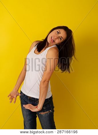 Pretty Girl With Dark Hair In Casual Clothes In Good Mood Makes A Wry Face And Makes A Face On A Bri