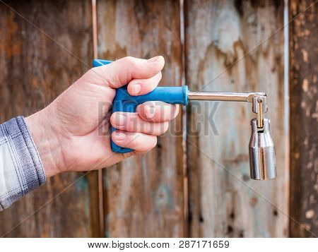 Hand Holding Key For Replacing A Car Candle On A Wooden Background, Husky Metric Drive Ratcheting