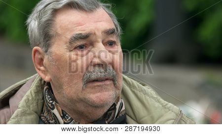 09.05.2018 - Kyiv, Ukraine. Close Up Nostalgic Senior Man With Mustache Looking Aside Outdoors. Sad 