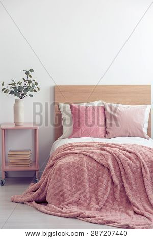 Pink Pillows And Cozy Blanket On Single Bed In Elegant Hotel Room, Copy Space On Empty White Wall