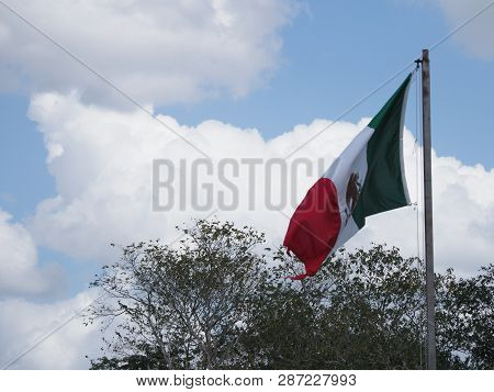 National Maxican Flag At Ancient Chichen Itza City Near Archaeological Site In Mexico With Trees And