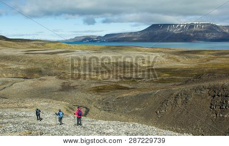 Hikers On The Background Of The Svalbard Landscape