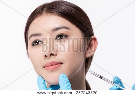 Surgery Concept. The Doctor Cosmetologist Makes The Rejuvenating Facial Injections Procedure For Tig