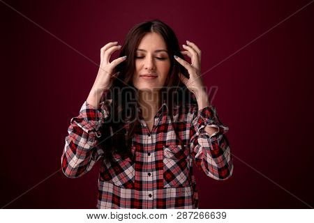 Angry Woman Feeling Bad And Has A Headahce. Picture Isolated Over The Dark Pink Background.