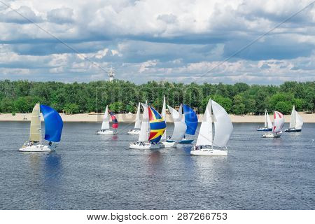 Regatta Competition Of Lake River Sailing Yachts Boats With White Sails And Gennakers, Reflected Sky