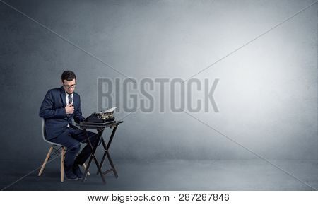 Man working hard on a typewriter in an empty space