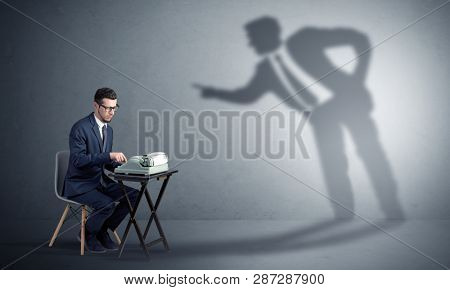 Little man working and a big shadow arguing with him