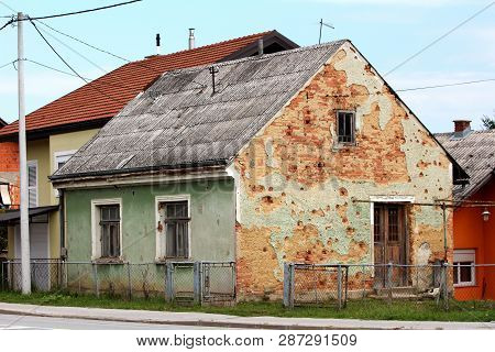 Shrapnel Damaged Small Family House During War Now Abandoned By Owners Surrounded With Uncut Grass A