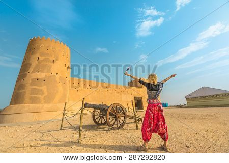 Travel In North Of Qatar. Carefree Woman At Al Zubara Fort, A Historic Qatari Military Fortress, Mid