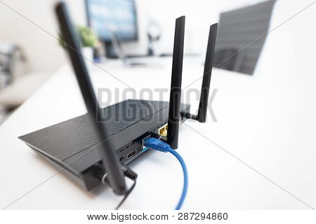 Modern Dual Band Wireless Router. Man Working In The Background. Fast And Wireless Internet Concept.