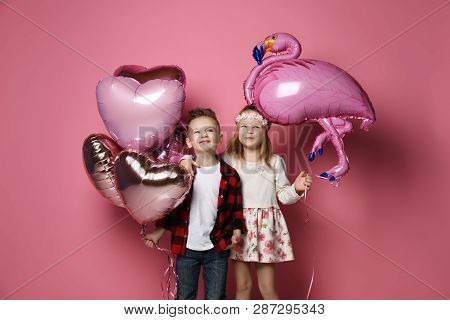 Joyfull Little Boy With Color Heart Balloons And Nice Little Girl With Flamingo Balloon Came Togethe