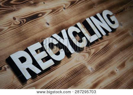 RECYCLING word made with building blocks on wooden board
