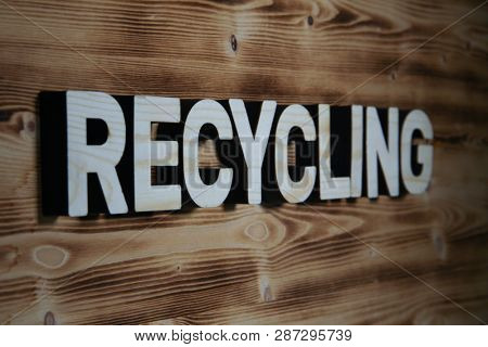 RECYCLING word made with building blocks on wooden board