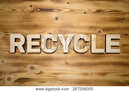 RECYCLE word made with building blocks on wooden board