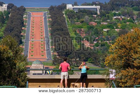 Couple On Mountain Lookout Viewing The City Of Canberra