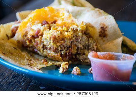 Bacon , Egg , And Cheese , Breakfast Taco On Flour Tortilla Close Up On Taco With Red Hot Salsa