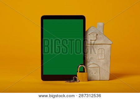 Tablet Screen Lock With A Green Screen, Lock And Model Home, On A Yellow Background