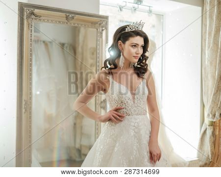 Beautifu bride choosing wedding dress in a wedding salon
