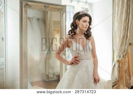 Beautifu bride choosing wedding dress in a wedding salon