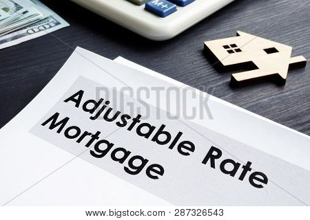 Adjustable Rate Mortgage Arm Documents On A Table.