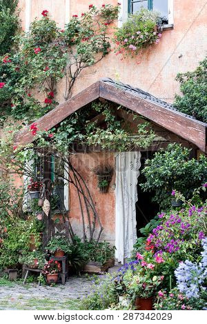 Colourful Entrance Of A Countryhouse, Decoration Of Many Flowers In Many Vases Around The Door