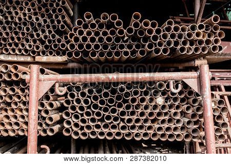 Scaffolding Storage Area In Outdoor, Detail Of Stacks Of Pipes, Poles, Used And Rusty Staffolding