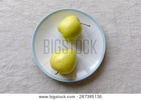 Ugly Food Concept With Misshapen Fresh Healthy Juicy Golden Apples On A Plate Over A Textured White 