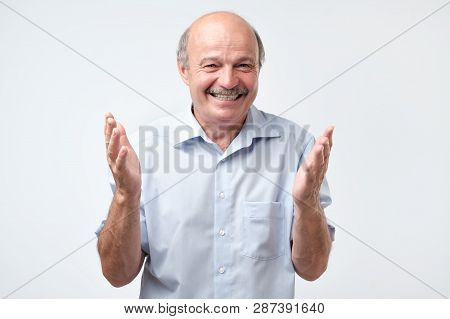 Happy Bald Senior Man Bragging About The Big Size Of Something