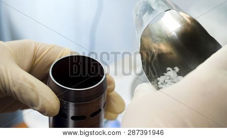 Close Up Of Hands In Medical Gloves Putting Chemical Powder From Chemical Scoop To Small Metal Conta