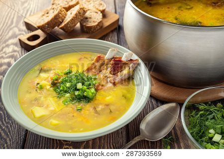 Fragrant Yellow Split Pea Soup  With Smoked Pork Ribs  On A Wooden Table.