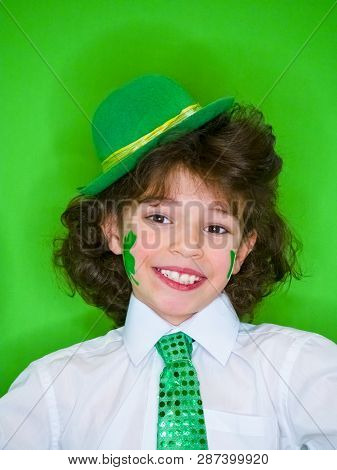 Hispanic Child Boy Having Fun During Saint Patrick Celebrations Over A Green Background. A Little Bo