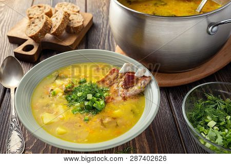 Fragrant Yellow Split Pea Soup  With Smoked Pork Ribs  On A Wooden Table.