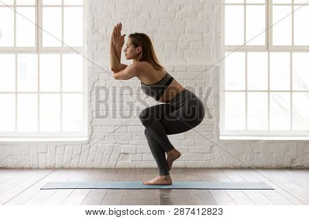 Beautiful Woman Practicing Yoga, Standing In Eagle Pose, Garudasana
