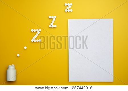 White Round Somnifacient Pills On Yellow Background. Copy Space For Text. Vertical Arrangement