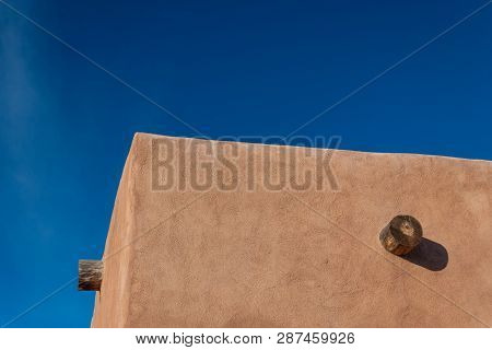 Red Adobe Exterior Corner, Exposed Vigas, Bright Blue Sky Creative Copy Space, Horizontal Aspect
