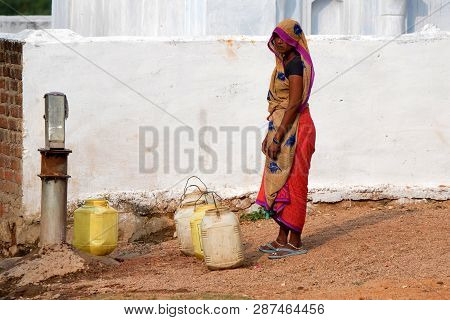 Orchha, India - 9 November 2017: Unidentified Indian Woman Pumps Water Outside