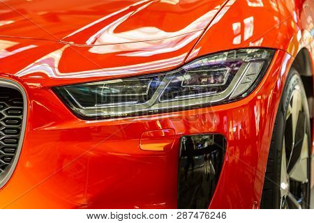 Singapore. March 2019. Orange Jaguar I-pace All Electric Suv. Front View, Led Headlights And Grill, 