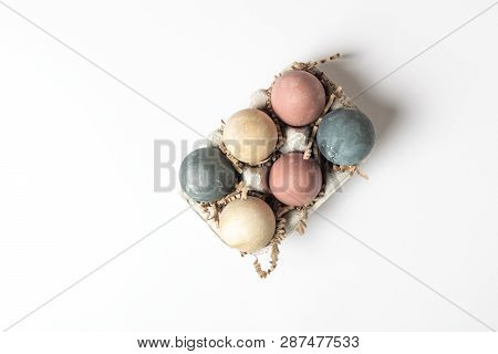 Selective Focus Of Coloured Decorated Easter Eggs In Cardboard Container, Minimal On White