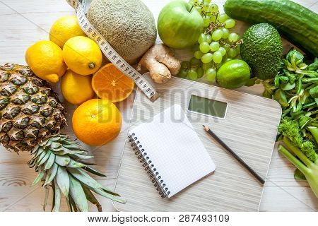 Flat Lay Composition With Scales, Healthy Vegetables And Fruit On Wooden Background. Weight Loss Die