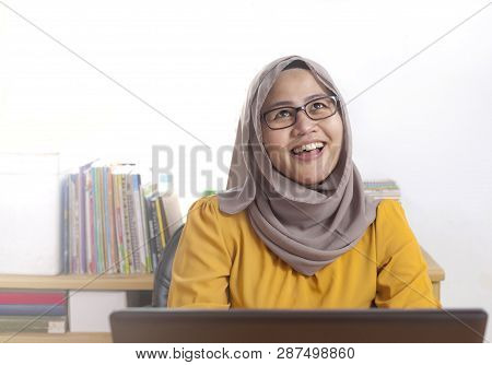Muslim Businesswoman Working On Laptop At The Office, Thinking Gesture
