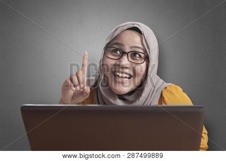 Muslim Businesswoman Working On Laptop At The Office, Thinking Gesture