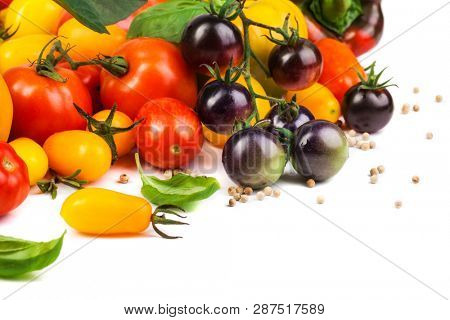Assorted tomatoes and vegetables isolated on white background. Photo for your design