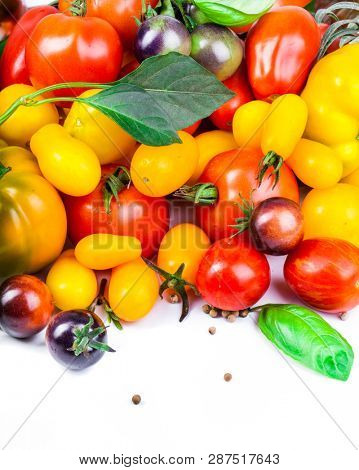 Assorted tomatoes and vegetables isolated on white background. Photo for your design