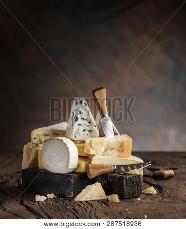 Assortment of different cheese types on wooden background. Cheese background.