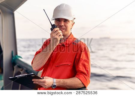 Deck Officer On Deck Of Offshore Vessel Holds Vhf Walkie-talkie Radio