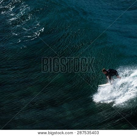 MAUI / USA - 14 DECEMBER 2018: Surfer takes off on the perfectly shaped ocean wave